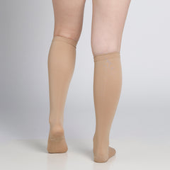 Beige knee-high socks worn by a person on a plain background